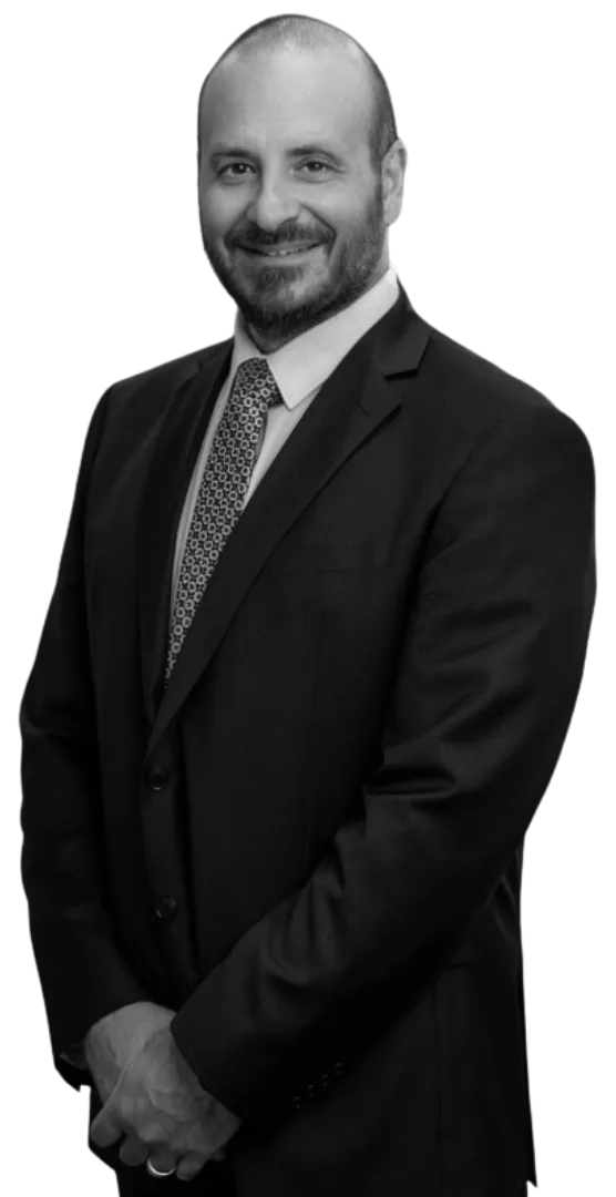Black-and-white image of Phil Testa with a suit smiling at the camera.