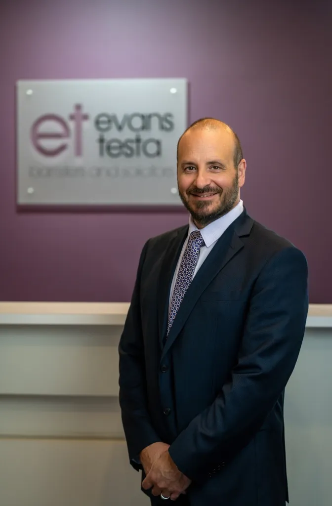 Phil Testa in front of ET Law signage